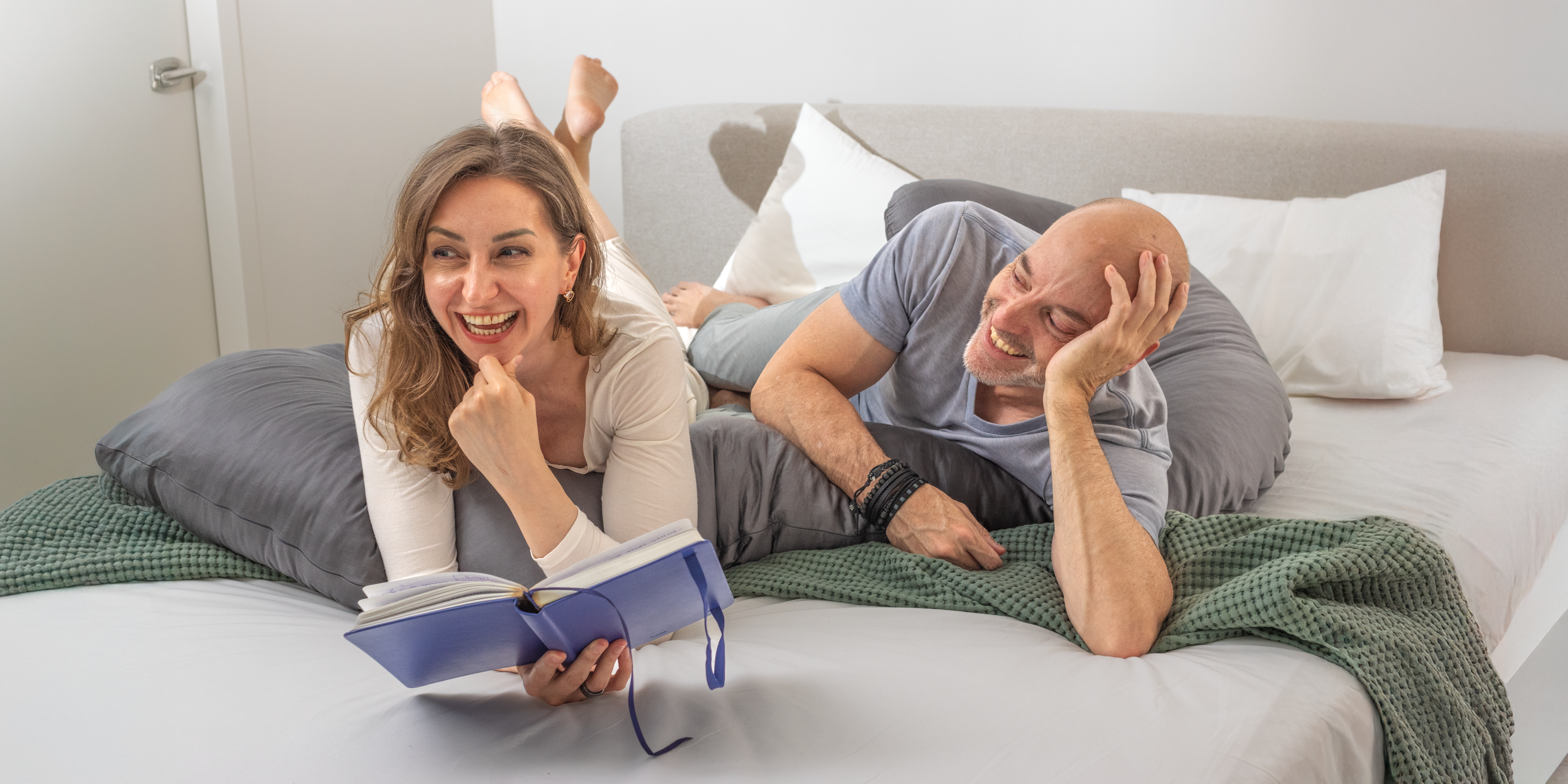 Happy couple relaxing with Comfybud body pillow, enjoying premium comfort, back support, and cozy moments at home
